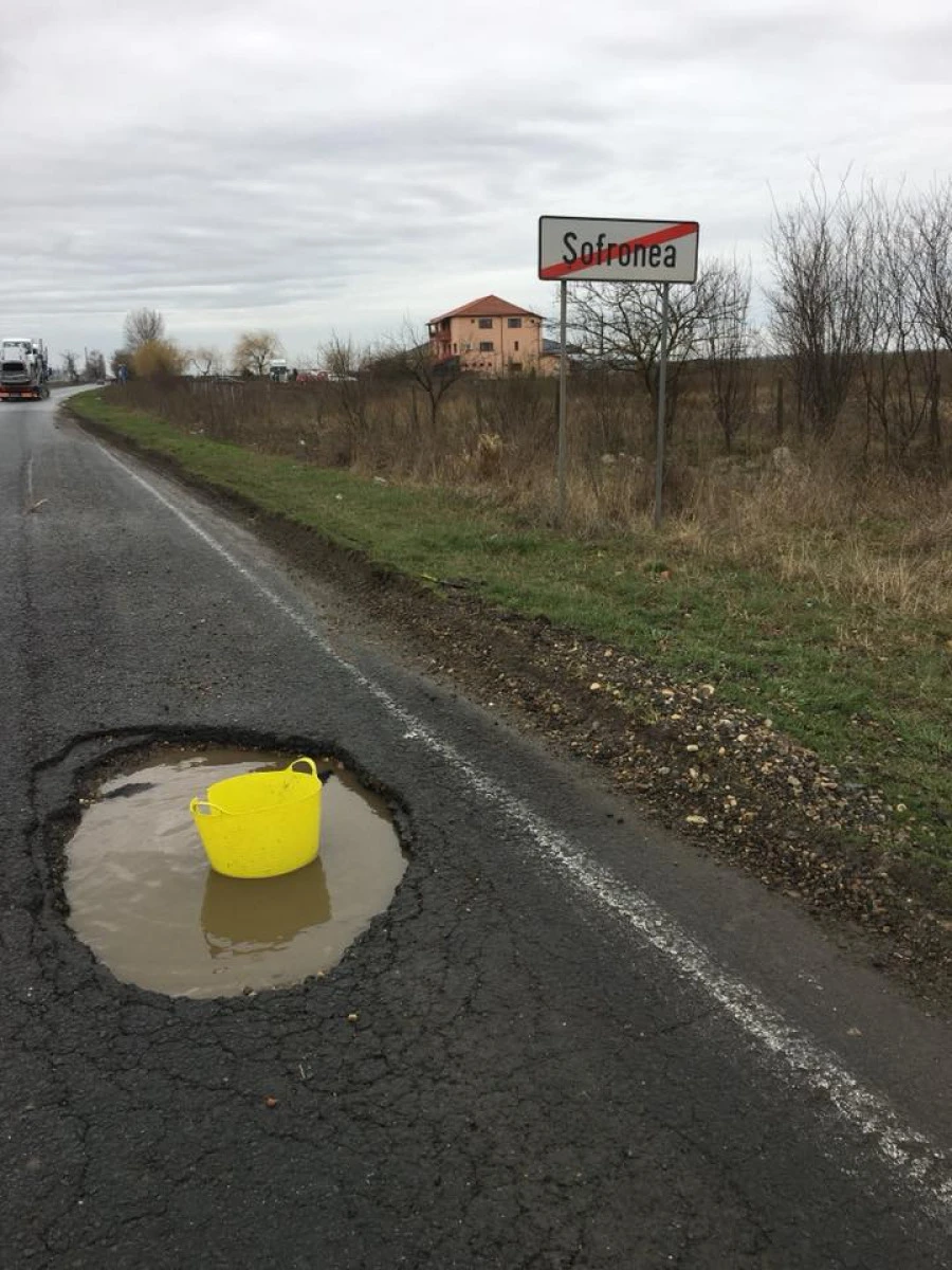 (FOTO) Craterele de pe Arad - Curtici sunt semnalizate cu găleți și lăzi de suc