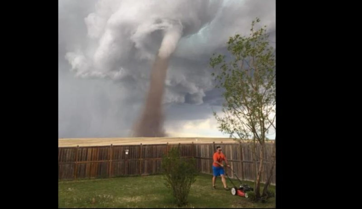 Un om cu adevărat calm! Tunde iarba, deși în spatele lui este o tornadă