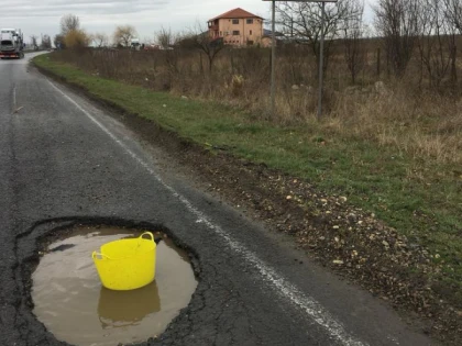 (FOTO) Craterele de pe Arad - Curtici sunt semnalizate cu găleți și lăzi de suc